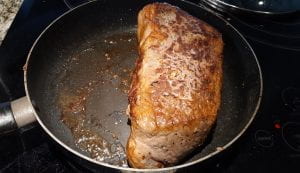 Browning a roast in a skillet.