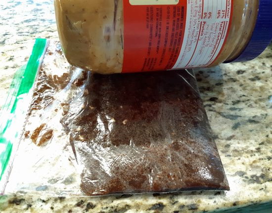 Baggie fudge being flattened by rolling with peanut butter jar